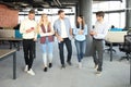 Full length of young people in smart casual wear discussing business and smiling while walking through the office Royalty Free Stock Photo