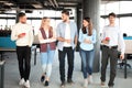 Full length of young people in smart casual wear discussing business and smiling while walking through the office. Royalty Free Stock Photo