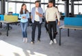 Full length of young people in smart casual wear discussing business and smiling while walking through the office Royalty Free Stock Photo