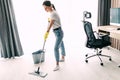 Full length of young woman cleaning hardwood floor of living room at home Royalty Free Stock Photo