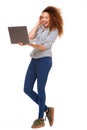 Full length young woman smiling with laptop against isolated white background Royalty Free Stock Photo