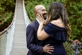 Full of love photo of an affectionate mixed race young couple holding each other on a suspension bridge at sunset Royalty Free Stock Photo