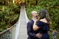 Full of love photo of an affectionate mixed race young couple holding each other on a suspension bridge at sunset Royalty Free Stock Photo