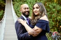 Full of love photo of an affectionate mixed race young couple holding each other on a suspension bridge at sunset Royalty Free Stock Photo