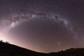 Full half-circle Milky way galaxy star shot across landscape