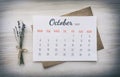 Full-month calendar: October 2021. Numbers, days of week, on white paper, on top of kraft paper envelope, next to