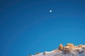 full moon above a ridgeline in a starlit sky