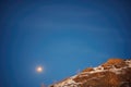 full moon above a ridgeline in a starlit sky Royalty Free Stock Photo