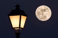 The full moon behind a beautiful street lamp. Royalty Free Stock Photo