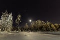 Full moon in clear sky shines over frozen Scandinavian wild forest, long exposure night photo, winter, virgin snowy landscape Royalty Free Stock Photo