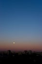 Full moon on clear sunrise sky and buildings under it