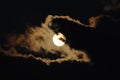 Full moon close-up and eerie white clouds against a black night sky. The big moon on a dark night The clouds gather together in Royalty Free Stock Photo