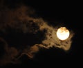 Full moon close-up and eerie white clouds against a black night sky. The big moon on a dark night The clouds gather together in Royalty Free Stock Photo