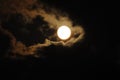 Full moon close-up and eerie white clouds against a black night sky. The big moon on a dark night The clouds gather together in Royalty Free Stock Photo