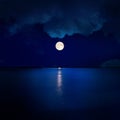 full moon in clouds over water Royalty Free Stock Photo