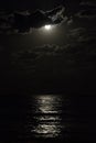 Full moon in a cloudy night sky reflecting moonlight on sea Royalty Free Stock Photo