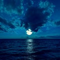 Full moon in dramatic sky over water Royalty Free Stock Photo