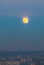 Full moon at dusk above polluted city of Belgrade