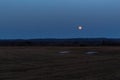 full moon, evening time, moon hovered over the field with the remains of snow, April 2022, Tomsk Royalty Free Stock Photo