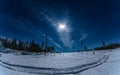 Full Moon lights over winter snowy forest, dark blue night sky with stars and some clouds highlighted by lunar light. Snowmobile Royalty Free Stock Photo