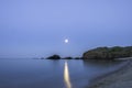 Full moon and moonbeam between the rocks on cala Presili, Menorca, Spain.