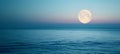 Full moon over blue sea water in pastel sky, evening natural background Royalty Free Stock Photo