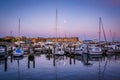 A full moon over boats docked at twilight, in Fells Point, Baltimore, Maryland.