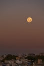 Full moon over the city in sunset Royalty Free Stock Photo