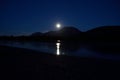 Full moon over night mountain with reflection on river surface Royalty Free Stock Photo