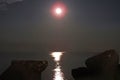 Full Moon reflection over the sea, at night.