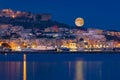 Full moon rises over coast of seaside city Royalty Free Stock Photo