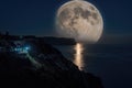 The full moon rises in a starry night sky over the sea and rocky cliffs. The concept of calmness, silence and unity with nature Royalty Free Stock Photo