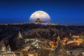 Full moon rising above Uchisar castle in Cappadocia, Turkey