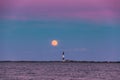 Full moon rising through a hazy horizon behind a beautiful lighthouse. Fire Island, NY Royalty Free Stock Photo