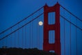 Full moon rising in June of 2022 alongside the north tower of the Golden Gate Bridge in San Francisco Royalty Free Stock Photo