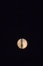 Full moon rising into the night sky with a radio antenna and transmission tower with a red signal light Royalty Free Stock Photo