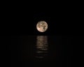 Full Moon Rising Over Calm Sea with reflection on water Royalty Free Stock Photo