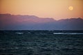 Full moon rising over sea and mountains Royalty Free Stock Photo