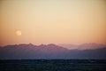 Full moon rising over sea and mountains Royalty Free Stock Photo