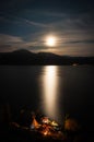 Full moon sets over a Syilx tipi along Okanagan Lake, British Columbia, Canada