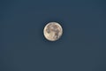 A full moon in the sky, a natural satellite visible from the ground, a round disc with visible craters