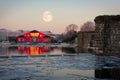 Full moon on top of rowing club in winter morning Royalty Free Stock Photo