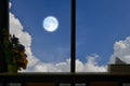 Full moon and white clouds in the window of house Royalty Free Stock Photo