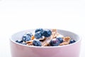 Full muesli bowl on a white table with blueberry and milk splash. Healthy breakfast cereals with milk, seed, fruit. Oat flakes Royalty Free Stock Photo