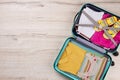 Full opened suitcase, wooden surface. Royalty Free Stock Photo