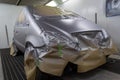 Full painting of a silver car in the back of a hatchback, some p