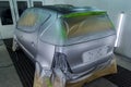 Full painting of a silver car in the back of a hatchback, some p