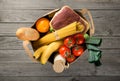 Full paper bag of different groceries on wooden background Royalty Free Stock Photo