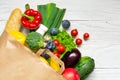 Full paper bag of different health food on white wooden background