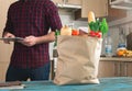 Full paper bag of food on wooden table in kitchen Royalty Free Stock Photo